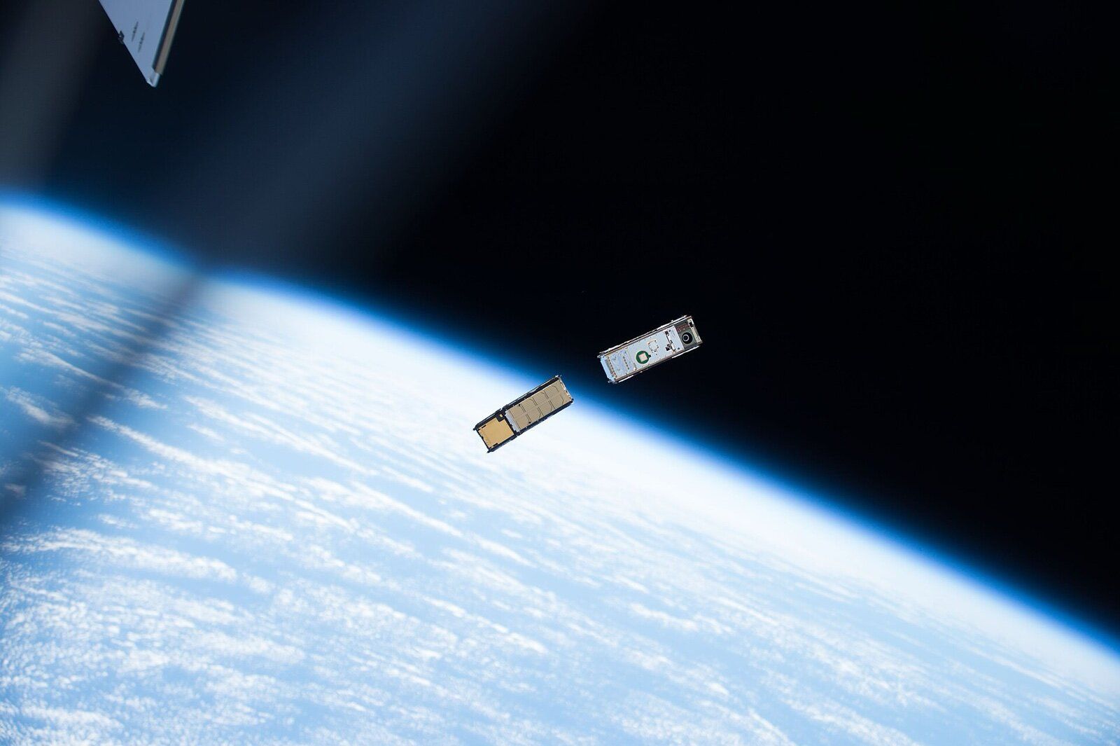 Two CubeSats released from the International Space Station above Earth